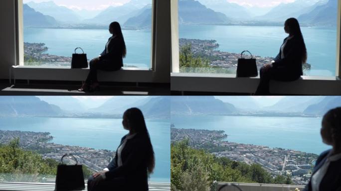 一名女销售人员透过窗户俯瞰城市湖全景