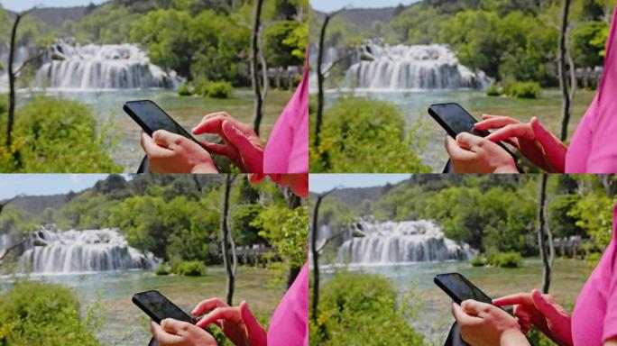 坐在Krka国家公园Skradin瀑布前的特写女人使用智能手机