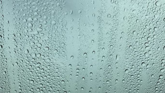 玻璃上的雨特写透明水滴落在