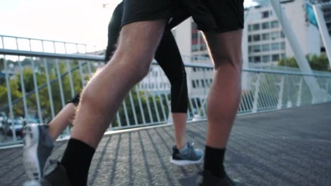 在城市的楼梯上奔跑的运动人士在街上进行激烈的健身运动。两个健康，活跃的朋友在早上慢跑做有氧运动的慢动