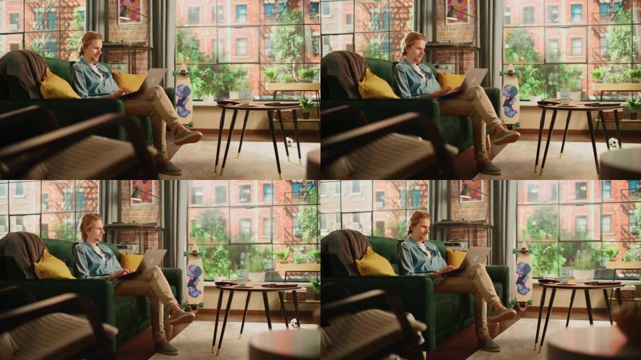 年轻英俊的成年男子坐在阁楼公寓的沙发上，在家用笔记本电脑工作。创意男性查看社交媒体，浏览互联网。从大