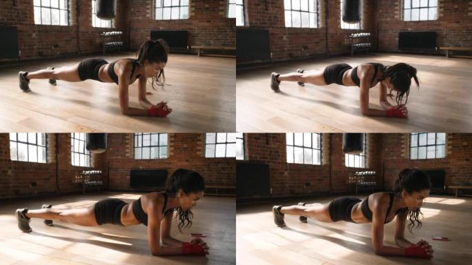 4k视频片段，一名年轻女子在健身房的木板位置