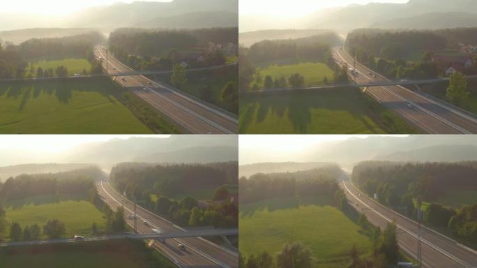 无人机: 日出照亮了通勤者在乡村高速公路上来回行驶。