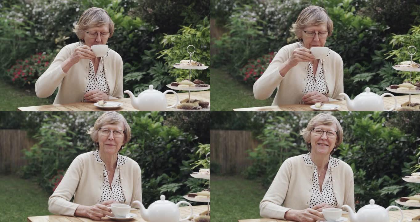 4k视频片段，一名老年妇女在花园里喝杯茶和一些蛋糕
