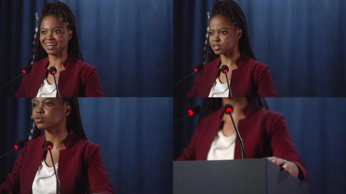身穿红色夹克的年轻非洲裔美国政治家站在美国国旗的蓝色背景下发表演讲