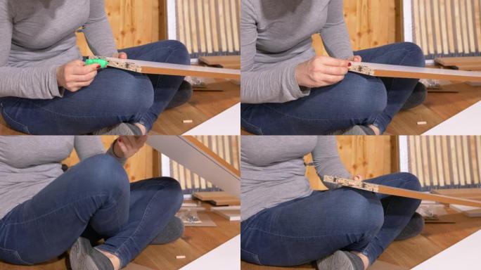 特写女人在组装家具时将胶水涂在木板的孔中