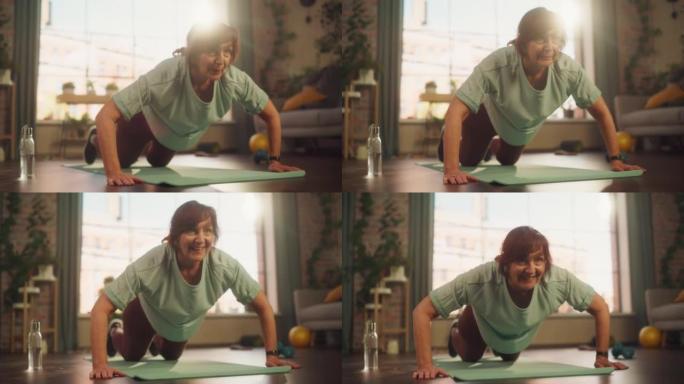 快乐健康的高级女性在瑜伽垫上训练，在阳光明媚的公寓里在家晨练时做Burpees练习。健康的生活方式、