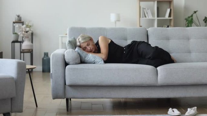 沉稳的成熟女人睡在客厅的沙发上