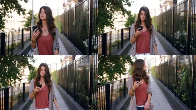 4k视频片段，一名妇女在外面散步时使用手机
