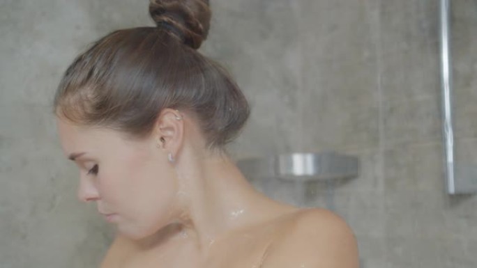 慢镜头，迷人的女孩在淋浴时用泡沫清洗皮肤