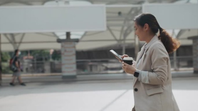 亚洲女子在城市中行走并使用智能手机