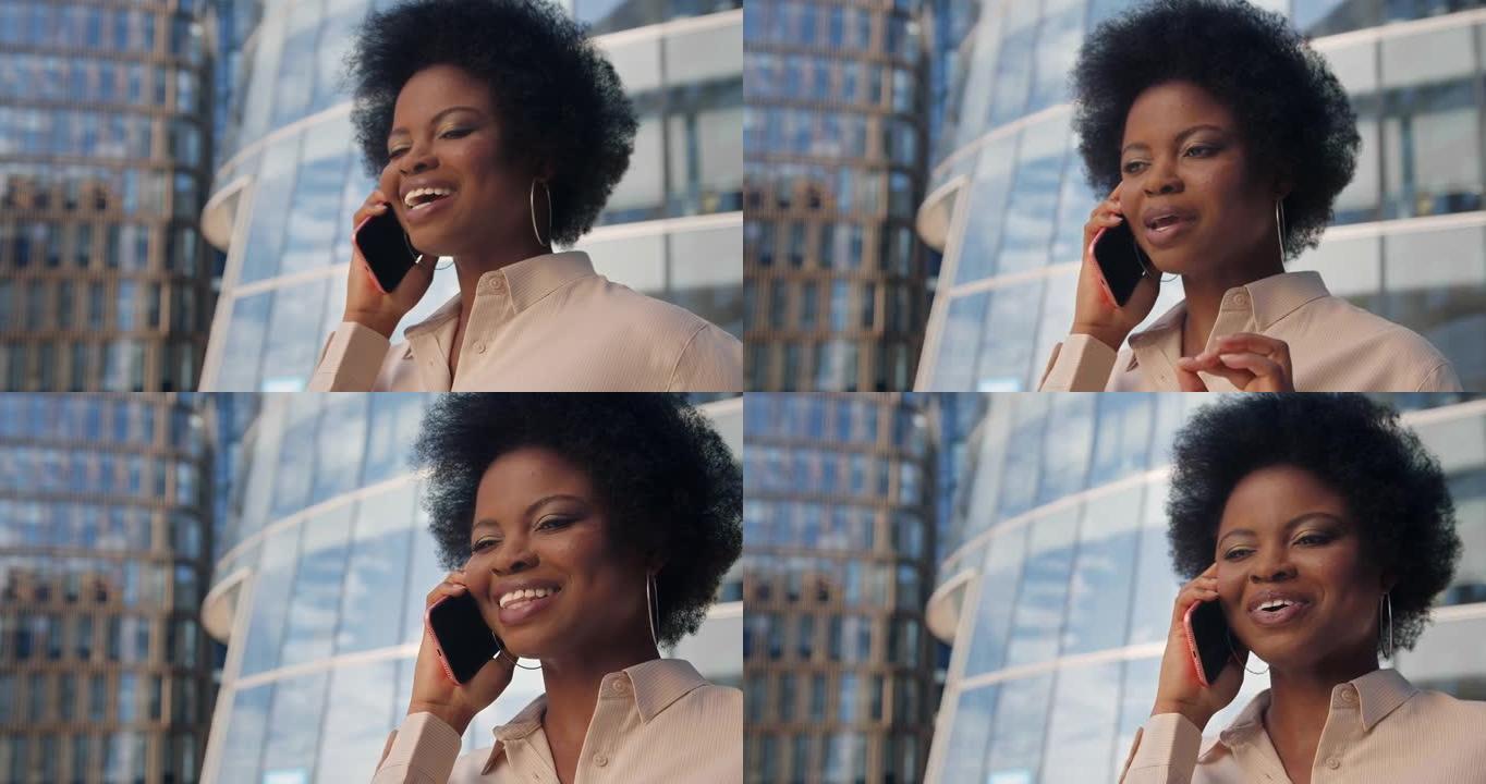 一位肤色黝黑的商务女士礼貌地在电话中讲话，背景为现代玻璃结构