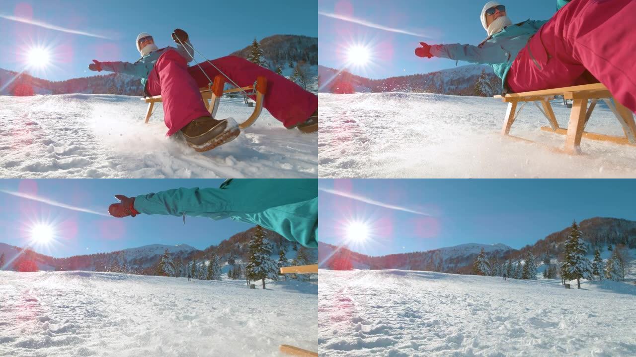 镜头耀斑: 快乐的高加索女人在木制雪橇上沿着雪山加速行驶。