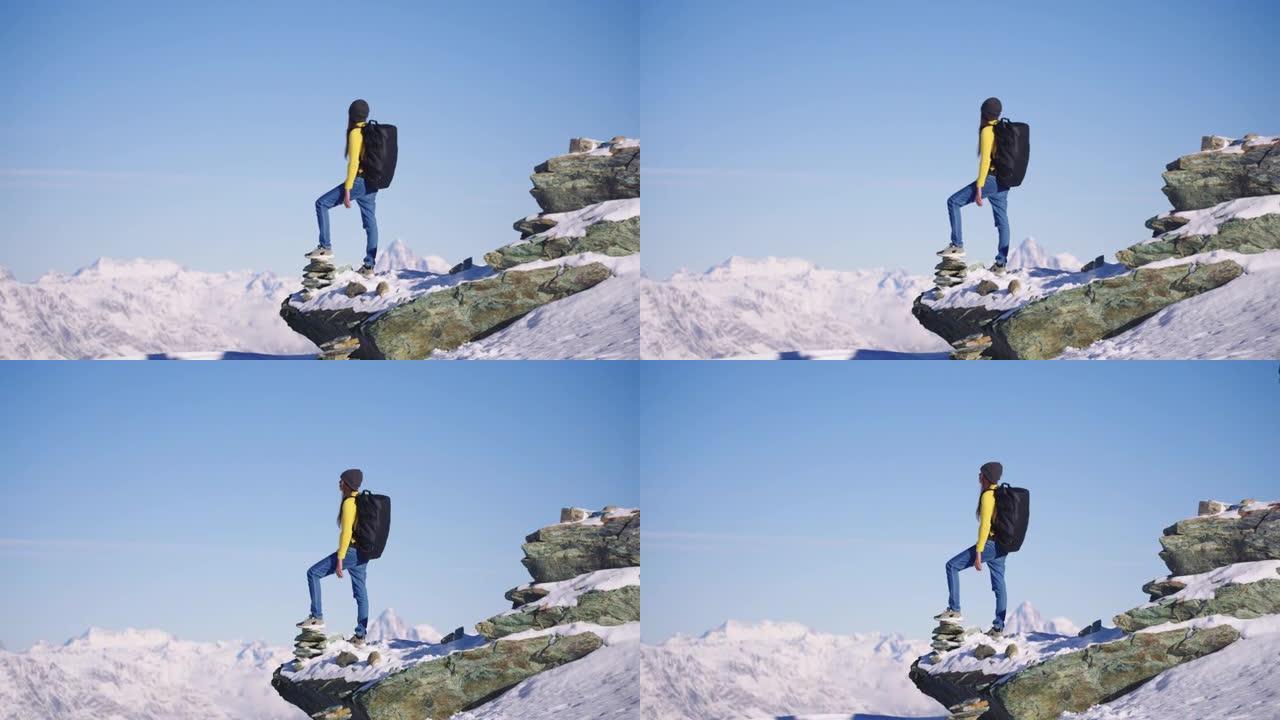 穿着黄色衬衫的年轻女性站在瑞士的山顶上。体验旅行与多样性。与阿尔法。