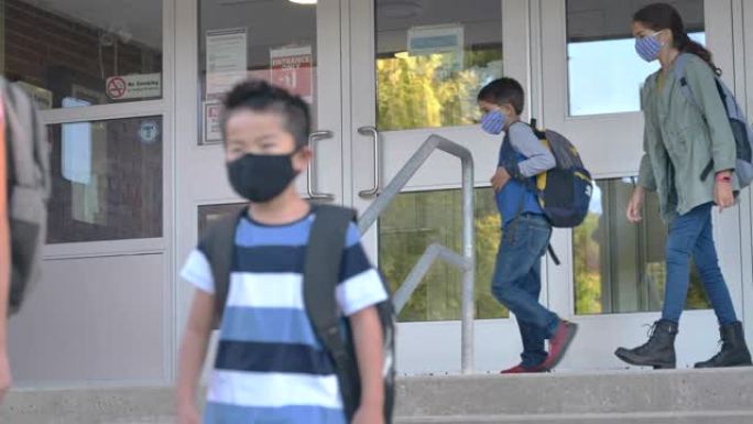 戴着面具的小学生正在离开学校