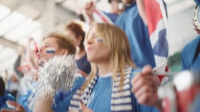 体育馆大事件: 美丽的欢呼女孩。一群脸上涂着彩绘的球迷欢呼，为他们的蓝色足球队获胜而呐喊。人们庆祝进