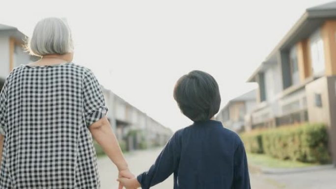 奶奶和孙子在村子里散步。