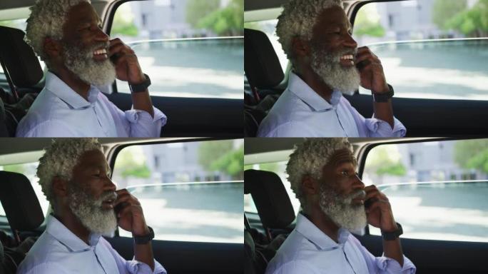 非裔美国高级男子坐在车里用智能手机聊天