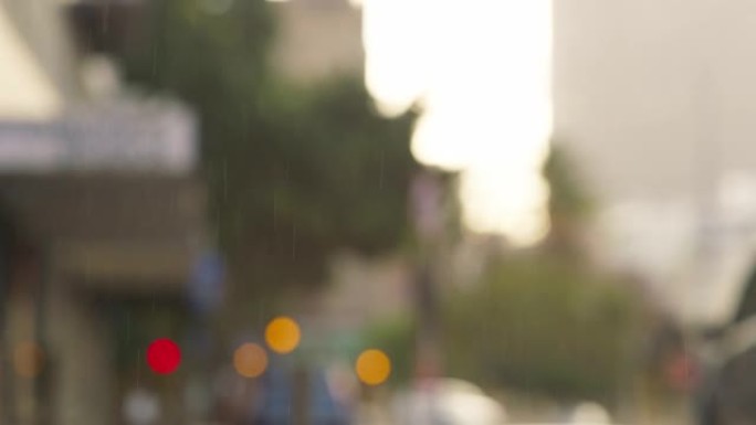 雨水，bokeh和城市背景模糊的冬季水滴在繁忙的道路附近的城市空间中。多雨的天气，建筑物，明亮的路灯