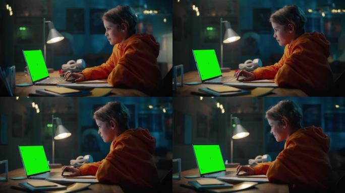 聪明的小男孩在绿屏显示的笔记本电脑上研究作业。快乐的青少年浏览教育研究，在笔记本上写作，学习学校材料