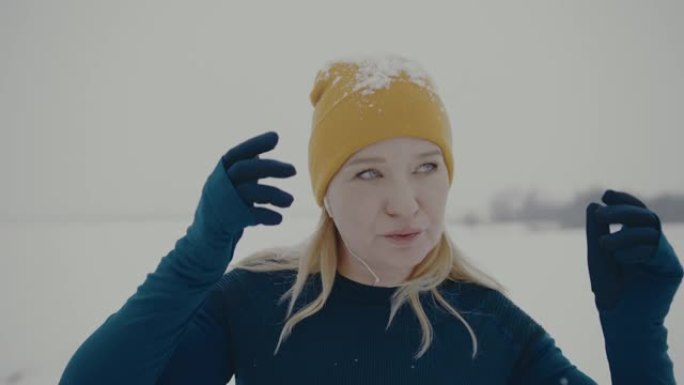 SLO MO肖像，一个女人在雪地里慢跑时看着相机