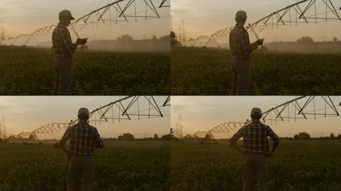 SLO MO Farmer使用他的智能手机控制玉米田地上的农业洒水装置