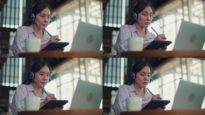 亚洲女性在笔记本电脑上戴无线耳机视频通话
