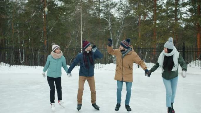快乐的情侣在冬季公园户外双人约会时滑冰击掌