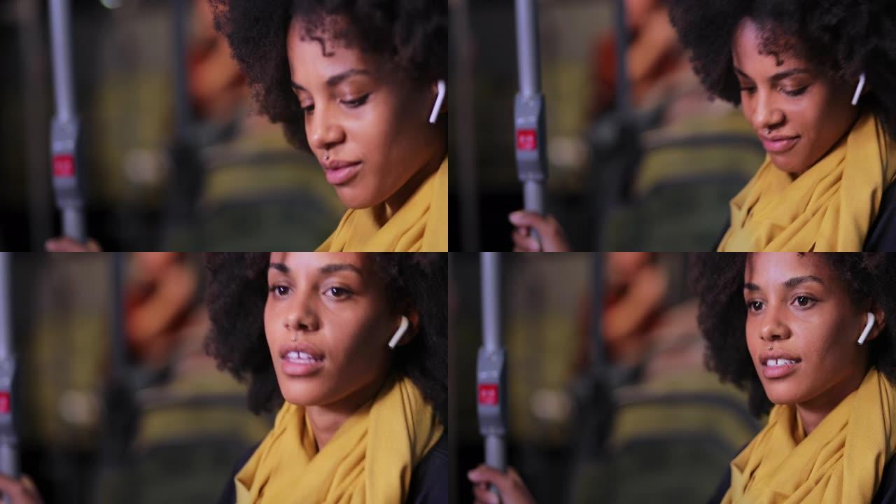 持耳机的非裔美国妇女在公共巴士上行驶