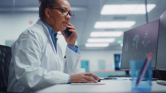 医学医院研究实验室: 黑人女性神经外科医生使用计算机进行脑部扫描MRI图像，与患病患者通电话。保健神
