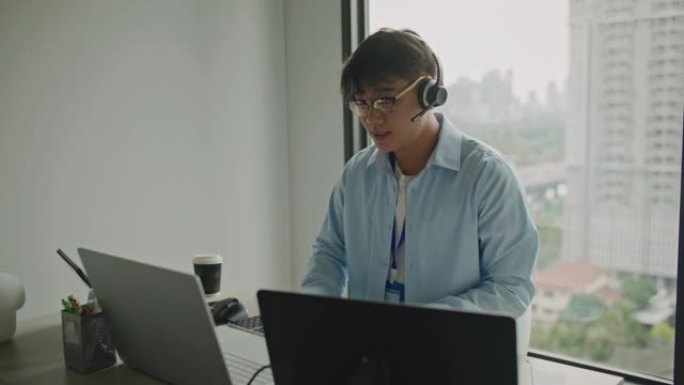 电话营销或呼叫中心，带耳机在办公室的电脑笔记本电脑上工作