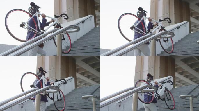 亚洲男子戴着口罩，在公司公园爬楼梯时背着自行车