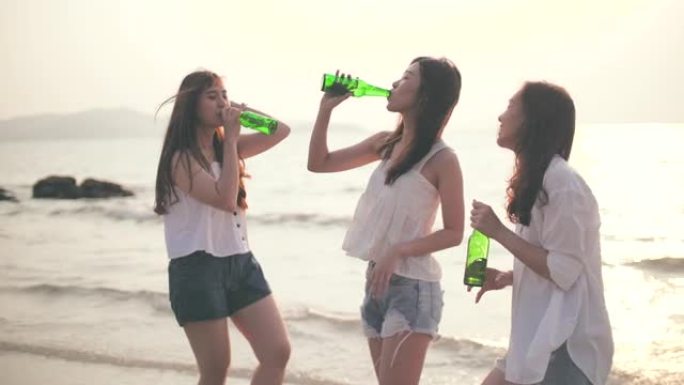 一群朋友在沙滩上快乐跳舞和娱乐喝酒