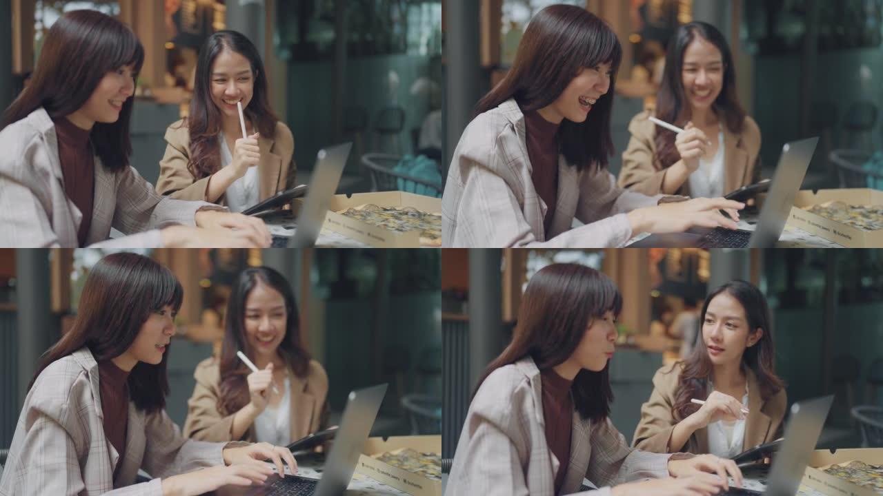 两个亚洲女性商业伙伴在咖啡馆聊天。