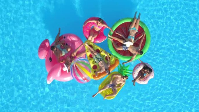 无人机: 在游泳池放松时，在漂浮物上放松的朋友聚集在一起