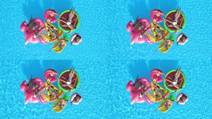 无人机: 在游泳池放松时，在漂浮物上放松的朋友聚集在一起
