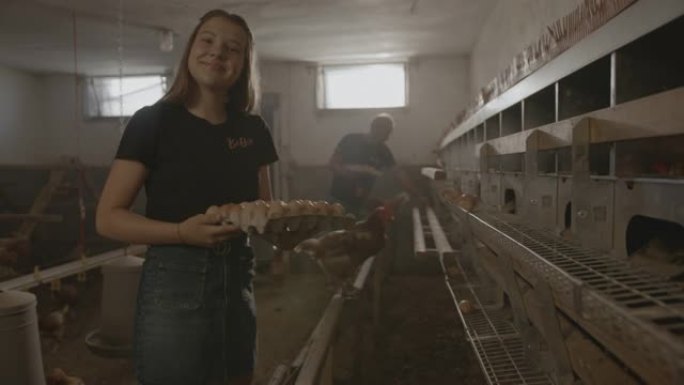 一个女孩的SLO MO肖像在鸡舍里采摘新鲜产下的鸡蛋