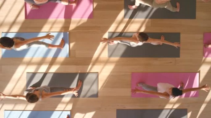 瑜伽课，女性团体运动和普拉提训练，在健康健身房工作室进行平静锻炼和伸展运动。以上，战士姿势平衡与健康