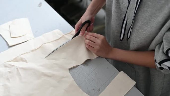 亚洲中国女性时尚大学生裁剪面料在大学工作坊做服装项目