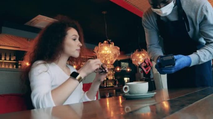 一名妇女用智能手表支付咖啡馆账单