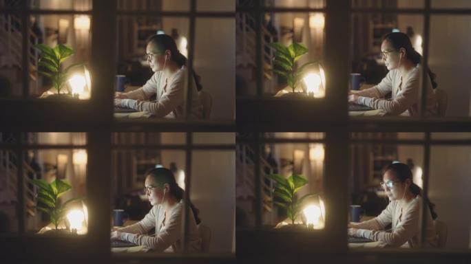 女人在晚上使用笔记本电脑工作时进行视频通话