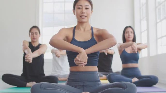 一群亚洲人在瑜伽课上伸展和放松