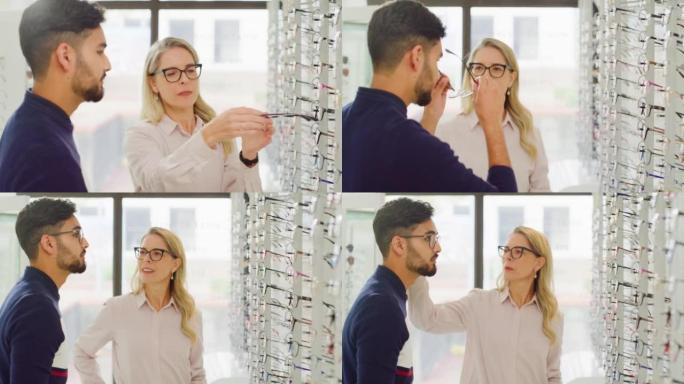 女性配镜师或验光师帮助顾客选择她商店货架上的眼镜。友好的成熟女人和店主在她的眼镜店帮助男人选择和试戴