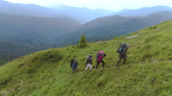 四个背着背包的徒步旅行者在山上行走