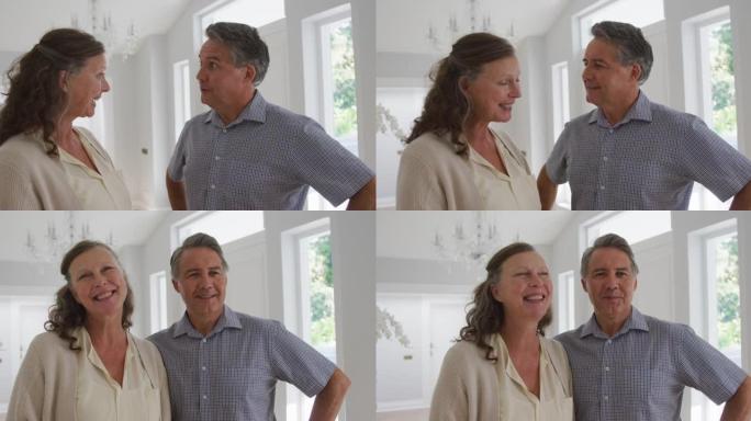 站在客厅微笑的快乐高级高加索夫妇的肖像