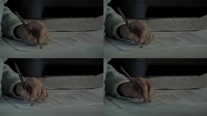 一个高中生在课堂上握笔的手。特写。