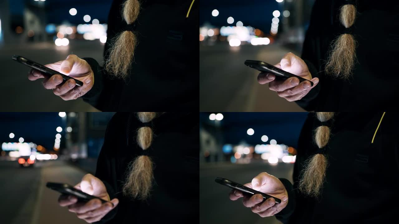 晚上在人行道上使用智能手机的胡须女士无法辨认的男人