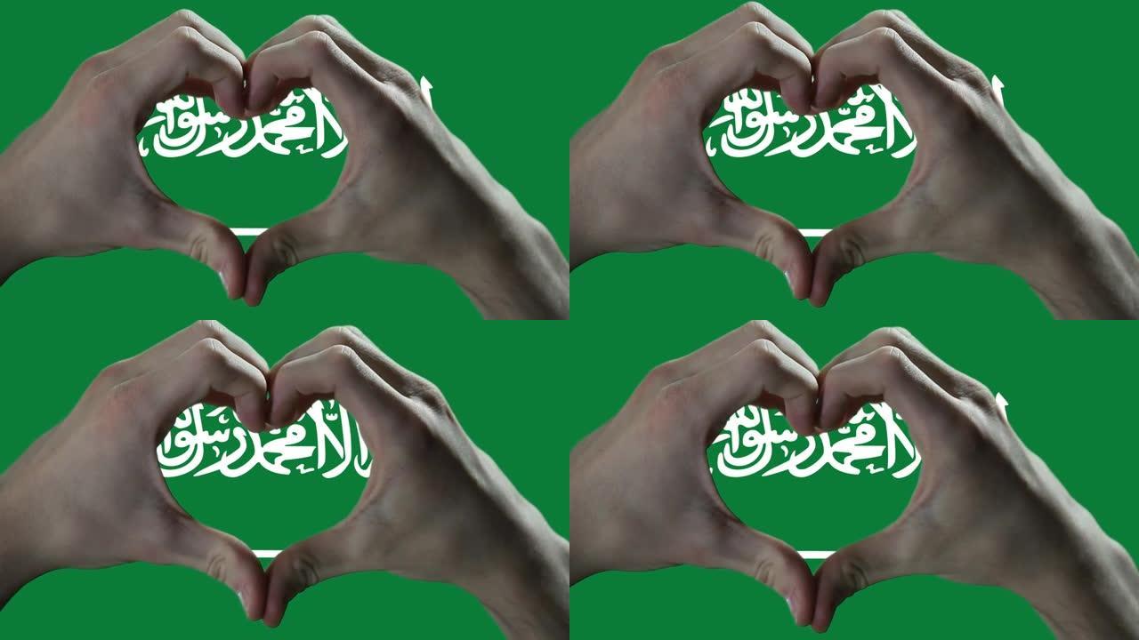 双手在沙特阿拉伯国旗上显示心脏标志。