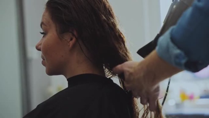 发型师在美容院为女性顾客干燥头发