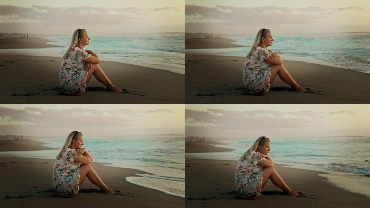 坐在海滩上的金发女人的景色，撒丁岛，意大利。